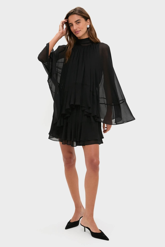 Black Cape Chiffon Mayfield Dress with classic, effortless layers, high neckline, flared sleeves, and a fun, tiered silhouette, styled with pointed-toe mule heels.